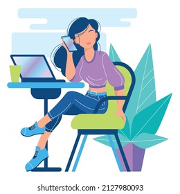 A young girl is sitting at a table and talking on the phone. There is a laptop on the table. Work in an office or cafe.
