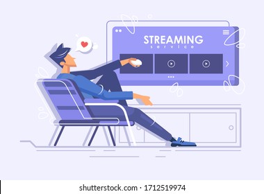 A young guy is sitting in a chair and watching a movie. Online movie theater. Streaming service concept. Online viewing of TV series at home.