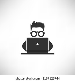 A young hacker with glasses hacks or searching by a laptop