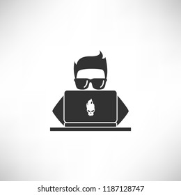 A young hacker with glasses hacks or searching by a laptop
