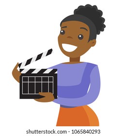 Young happy african-american woman working with a movie clapper board. Smiling assistant holding an open clapboard for filming. Vector cartoon illustration isolated on white background. Square layout.