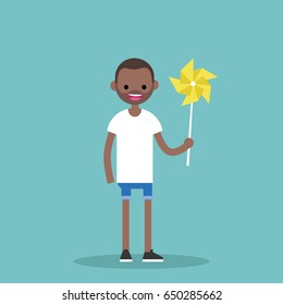 Young happy black character holding a toy windmill / flat editable vector illustration, clip art