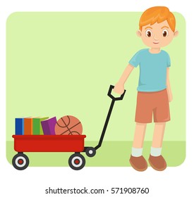 Young happy little boy playing with red wagon