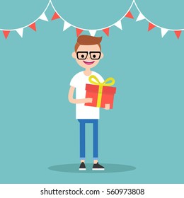 Young happy nerd holding a bright gift box / editable vector cartoon clip art