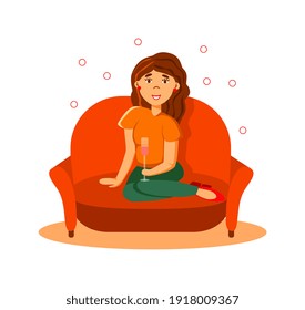 Young happy rich woman drinking champagne sitting on sofa
