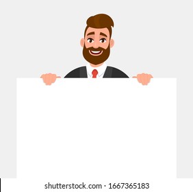 Young hipster businessman showing blank white poster or paper copy space area. Happy trendy person holding empty banner. Male presenting signboard or billboard. Cartoon illustration in vector style.
