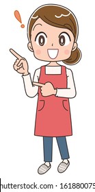 Young housewife wearing red apron.She is pointing while looking to the left.