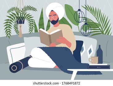 Young indian male character reading a book, cozy interior, tropical plants, pillows and boho style decorative elements, interior design
