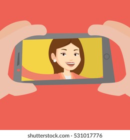 Young joyful caucasian woman making selfie. Smiling woman making selfie with cellphone. Woman taking selfie. Vector flat design illustration. Square layout.