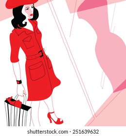 Young joyful woman with shopping bags on the background of shop windows