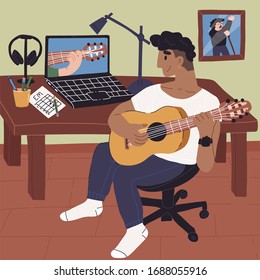 Young Latin guy learns how to play guitar online and watches webinar on his laptop at home. Stay home, online education, quarantine, self-isolation pastime, prevention of viral infection concept.