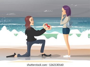 Young long-haired man making marriage proposal to beautiful young woman on ocean sandy beach on a cloudy day