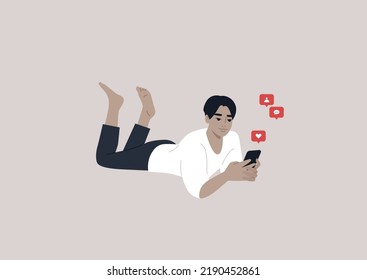 A young male Asian character lying on their stomach and checking their mobile phone notifications
