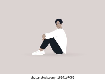 A young male Asian character sitting on the floor and hugging their knees, casual daily life scene