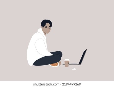 A young male Asian character sitting on the floor and working on their laptop with crossed legs
