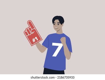 A young male Asian team supporter waving a foam finger, sports competition