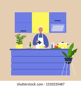Young male chief cooking food at the kitchen island table