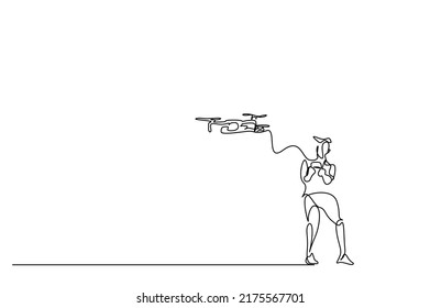 a young male is controlling his drone with a remote and having fun