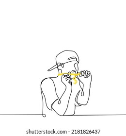young man in a cap with a visor pulled back on his fingers and shows a thick chain with large dollar sign - one line drawing vector. concept of showing off one's jewelry, rapper style, hip hop or rnb