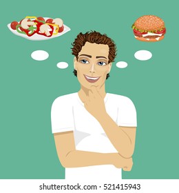 young man choosing between hamburger and salad. Healthy and junk food concept