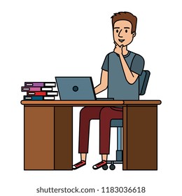 young man at desk with laptop and books