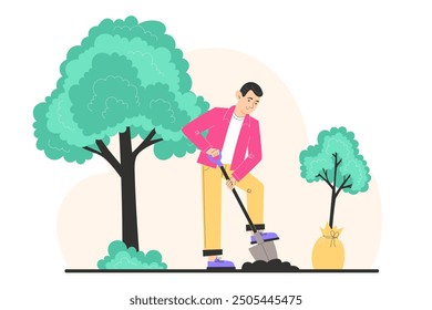 A young man digs the ground with a shovel and plants a young tree