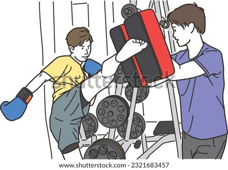 Young man doing martial arts kicks and male trainer with mitts
