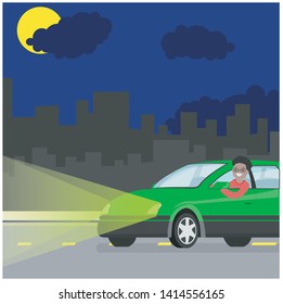 A young man drives a green car on the road at night.