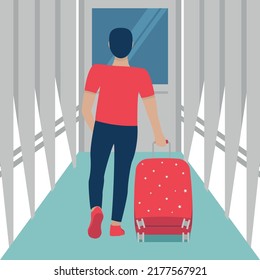 Young man going to the airplane with big suitcese by airport corridor