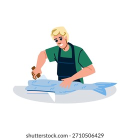 Hombre joven en camiseta verde y delantal de limpieza y cortar un pescado fresco entero en un mostrador de cocina con un cuchillo, preparando mariscos para una comida en un entorno profesional o doméstico