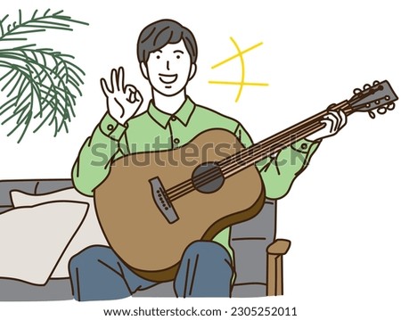 A young man with a guitar doing an OK pose
