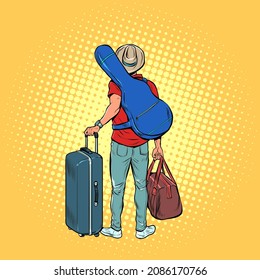 a young man with a guitar is a traveler flying on tour, luggage at the airport. Creative trip