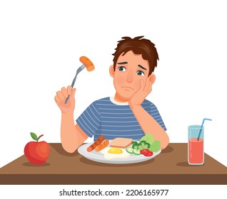 Young man has no appetite to eat food sitting in front of breakfast at table 