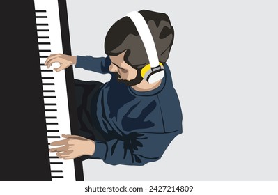 Young man with headphones playing piano. Top view. Copy space.