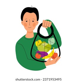 Young man holding bags of vegetables and fruits. Mesh eco bag full of vegetables, greens. Shopping local. Local food production. Sustainable lifestyle. Eco friendly concept. Zero waste