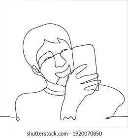 young man holds the phone and laughs - one line drawing. guy laughs looking at the screen of his smartphone.