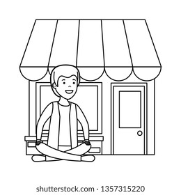 young man in lotus position with store building