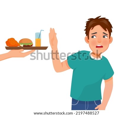 Young man on diet refusing to eat junk food like fried chicken and burger