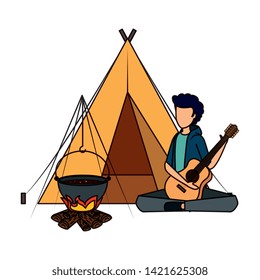 young man playing guitar with camping tent and woodfire