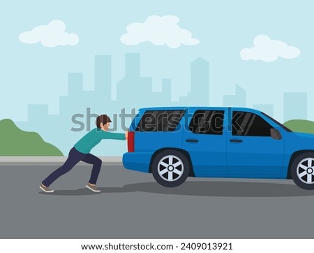Young man pushing a broken car on the road