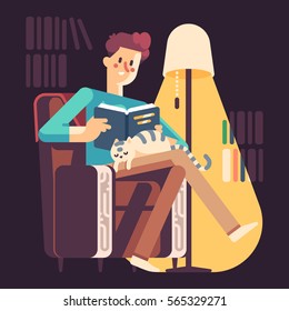 Young man reading a book in an armchair. Cat sleeping sweetly on his lap.