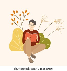 Young man is reading a book  in autumn forest