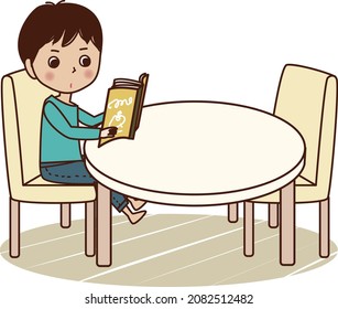 Young man reading a book at table.
