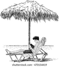 young man reads a book on the beach