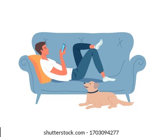 Young man  resting on the blue couch and his funny dog lying near on the floor 