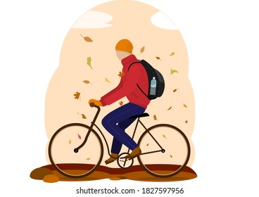 un joven monta una bicicleta bajo una caída de hojas. ropa cálida en otoño