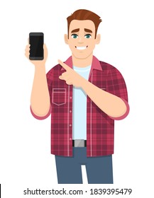 Young man showing a blank phone screen and pointing finger. Modern trendy person holding empty cellphone display. Male character introducing mobile device/gadget. Digital technology in vector cartoon.