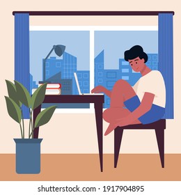 A young man is sitting at his desk at home with a laptop, looking out of the window at the city. Spending time at home, studying and working online