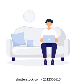 Young man sitting on the sofa working in hislaptop. Freelance concept of a boy studying. Can use for backgrounds, landing pages, web.