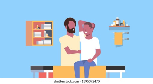 young man sitting on table african american masseur therapist doing healing treatment massaging patient body manual therapy physiotherapy concept horizontal copy space